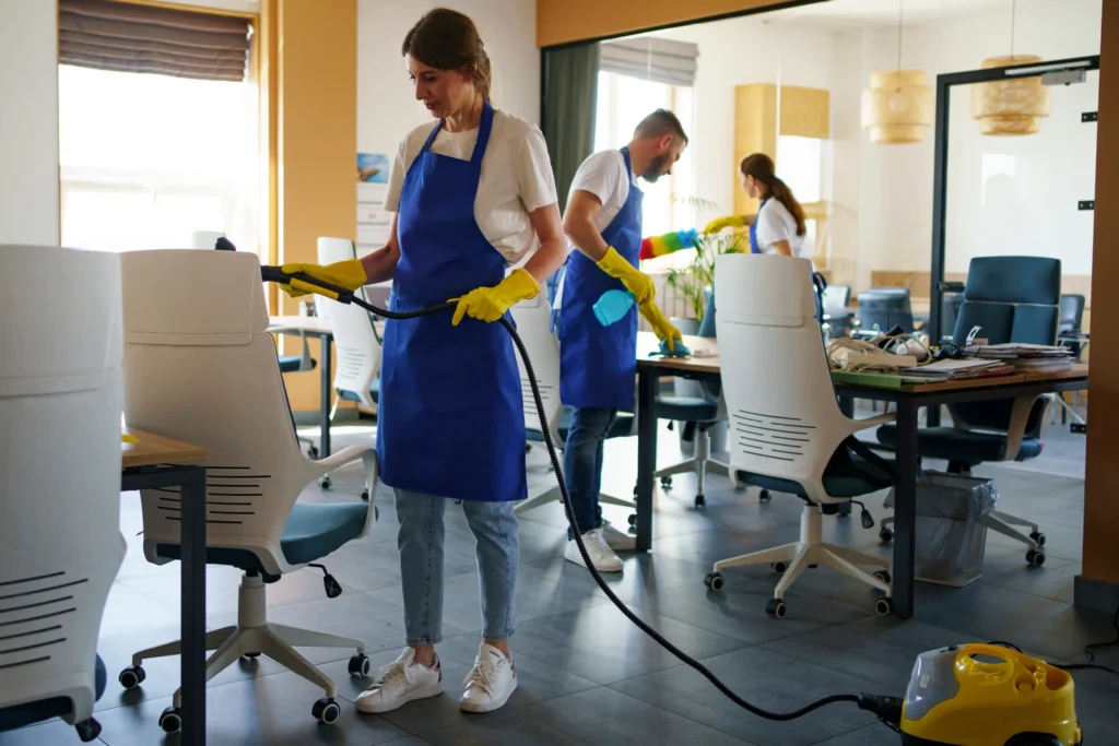 Professional cleaning service person using vaccum cleaner office scaled